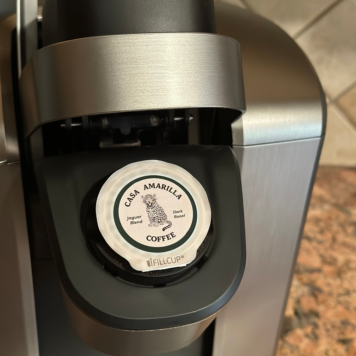 Casa Amarilla Coffee Jaguar Blend pod inserted in a coffee machine on a countertop